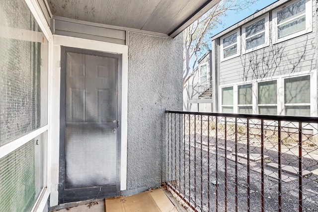 doorway to property with a balcony and stucco siding