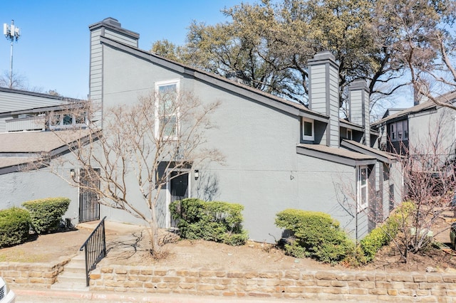 view of home's exterior with stucco siding and a chimney