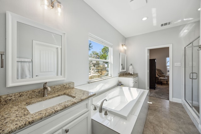 bathroom with visible vents, two vanities, a sink, a shower stall, and a garden tub