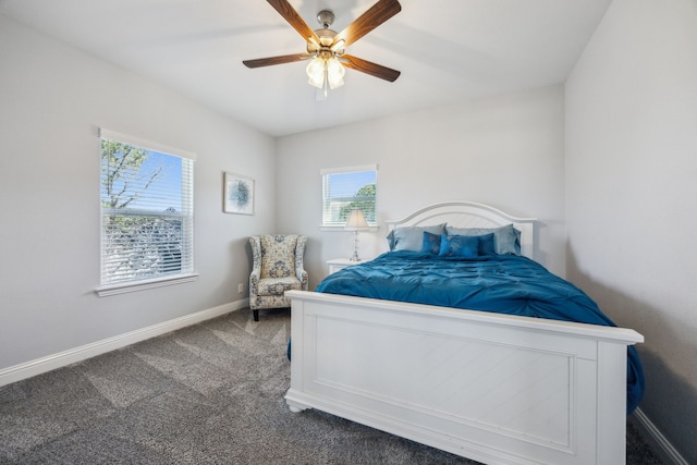 bedroom with ceiling fan, baseboards, and dark colored carpet