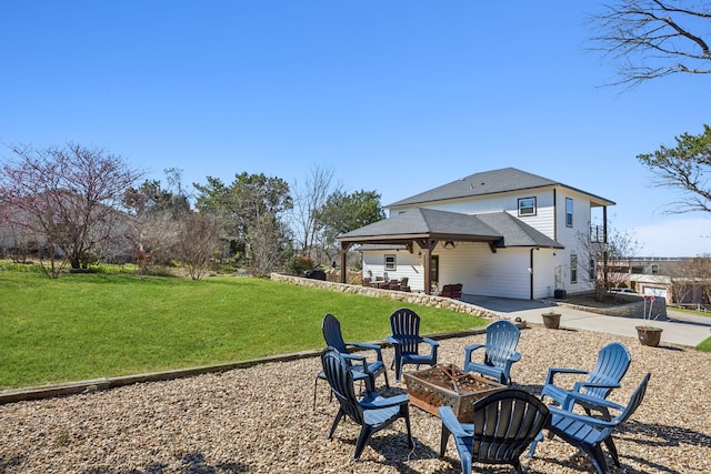 back of property featuring a patio area, an outdoor fire pit, a yard, and roof with shingles