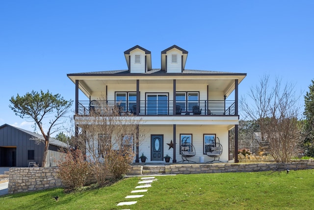 view of front facade featuring a balcony, covered porch, and a front lawn