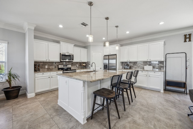 kitchen with a sink, ornamental molding, visible vents, and stainless steel appliances