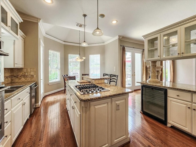 kitchen featuring visible vents, backsplash, a kitchen island, wine cooler, and appliances with stainless steel finishes