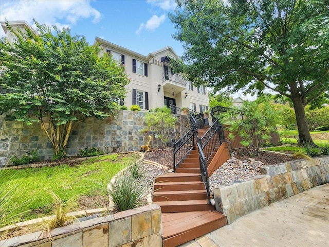 view of front of house with stucco siding and stairs