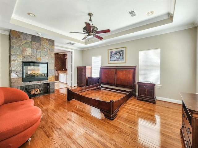 bedroom featuring a raised ceiling, visible vents, and light wood finished floors