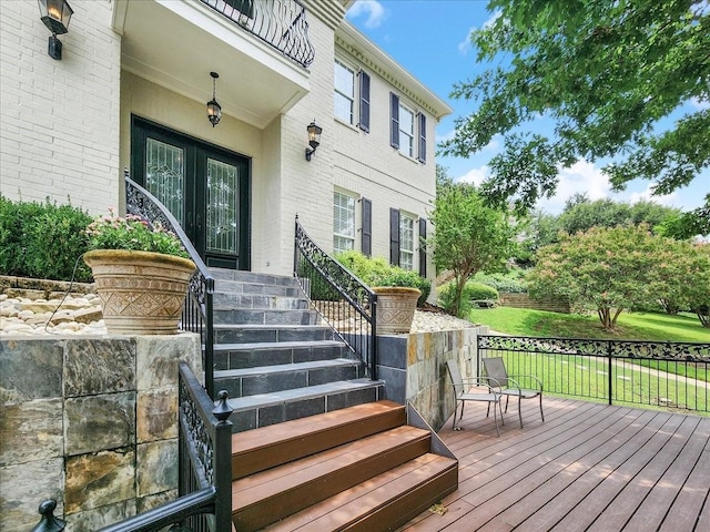 entrance to property with brick siding and a wooden deck