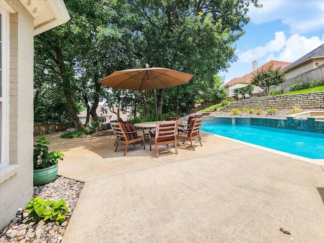 view of pool featuring outdoor dining space, a fenced in pool, a patio, and a fenced backyard