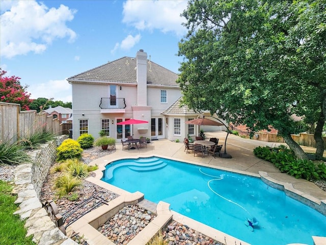 view of swimming pool with french doors, a fenced backyard, outdoor dining space, and a patio area