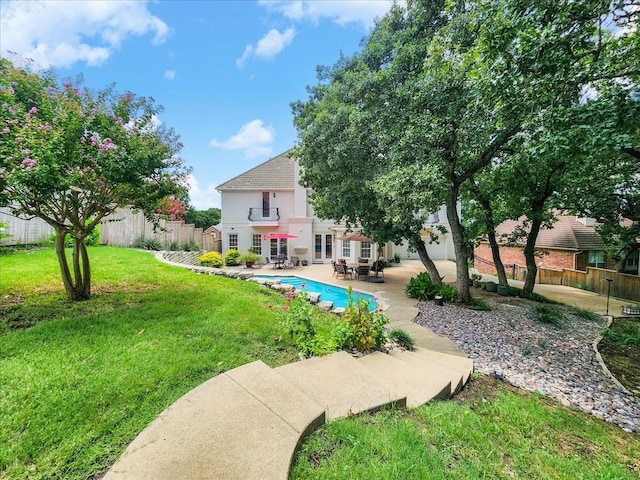 exterior space featuring a patio, a fenced in pool, a fenced backyard, french doors, and a lawn