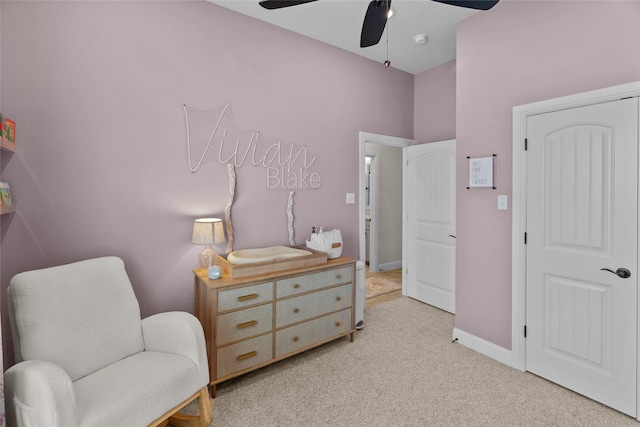 sitting room with baseboards, light colored carpet, and a ceiling fan