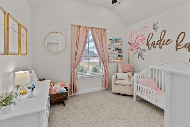 carpeted bedroom featuring a crib, lofted ceiling, a ceiling fan, and baseboards