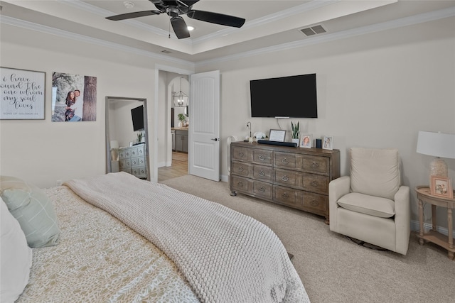 carpeted bedroom featuring visible vents, a raised ceiling, baseboards, and ornamental molding