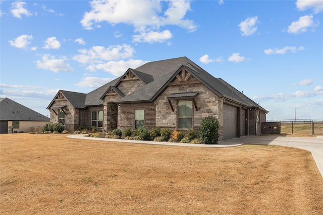 view of front of property featuring brick siding, a front lawn, a garage, stone siding, and driveway