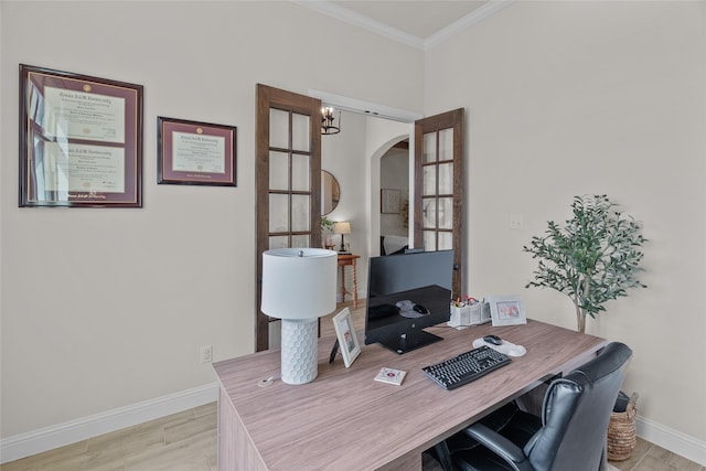 home office featuring baseboards, arched walkways, wood finished floors, and crown molding