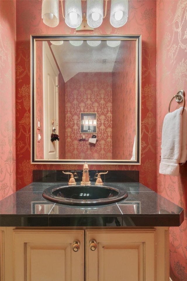 bathroom featuring wallpapered walls and vanity