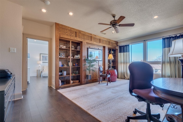 office area featuring built in shelves, a textured ceiling, dark wood finished floors, recessed lighting, and ceiling fan