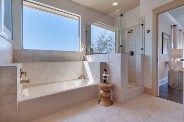 full bath with tile patterned floors, a bath, and a tile shower