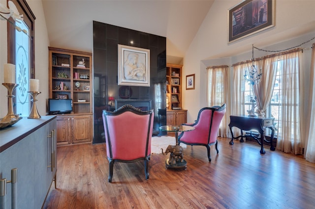 sitting room with high vaulted ceiling and light wood-style floors