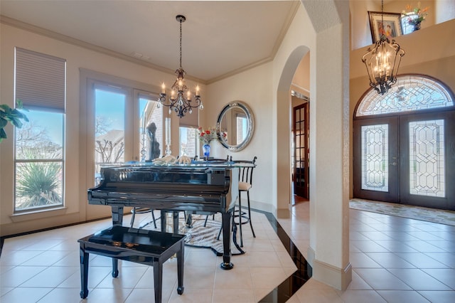 entrance foyer with arched walkways, a chandelier, and light tile patterned flooring