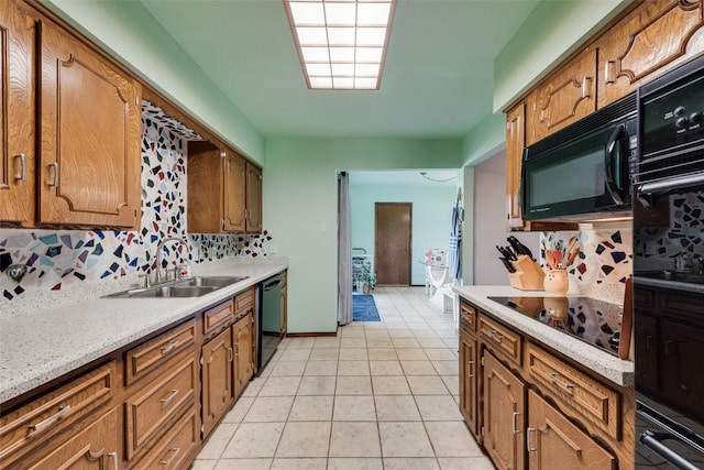 kitchen featuring a sink, black appliances, brown cabinetry, and light countertops