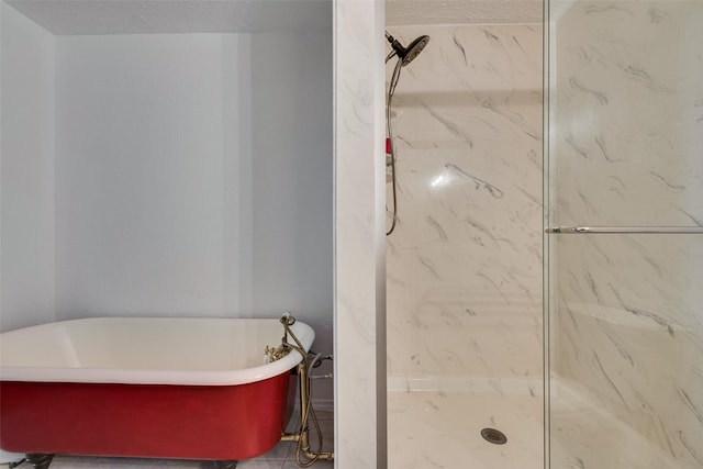 full bathroom with a marble finish shower and a freestanding bath