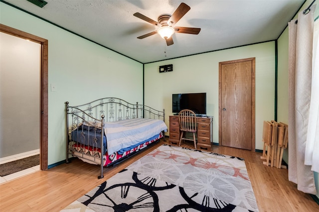 bedroom with baseboards, a ceiling fan, and wood finished floors