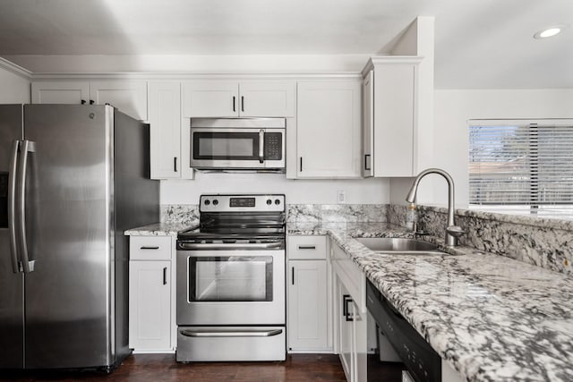 kitchen featuring a sink, light stone counters, dark wood-style flooring, and stainless steel appliances