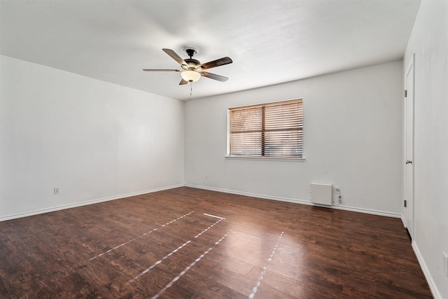 empty room featuring ceiling fan, baseboards, and wood finished floors