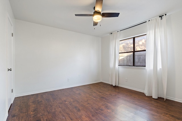 empty room with a ceiling fan, baseboards, and wood finished floors