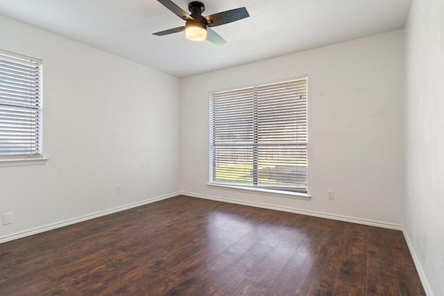 empty room featuring baseboards, wood finished floors, and a ceiling fan