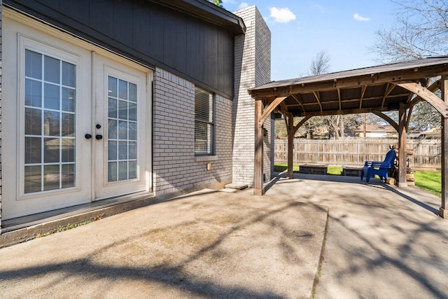 view of patio / terrace with french doors, fence, and driveway