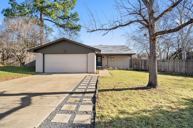 view of front of house featuring a front lawn, fence, concrete driveway, an attached garage, and brick siding