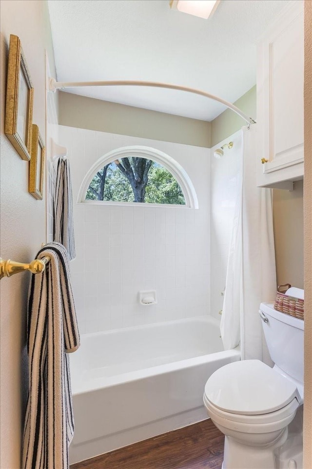 full bath featuring shower / tub combo, toilet, and wood finished floors