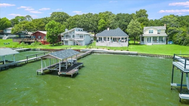 dock area with boat lift, a yard, and a water view