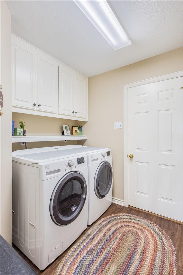 laundry room featuring wood finished floors, baseboards, cabinet space, and washing machine and dryer