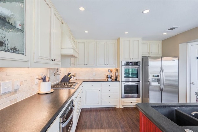 kitchen featuring white cabinetry, dark countertops, dark wood-style floors, and stainless steel appliances