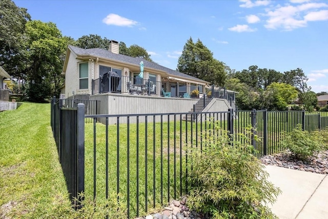 view of front facade featuring stairs, a chimney, a front lawn, and fence