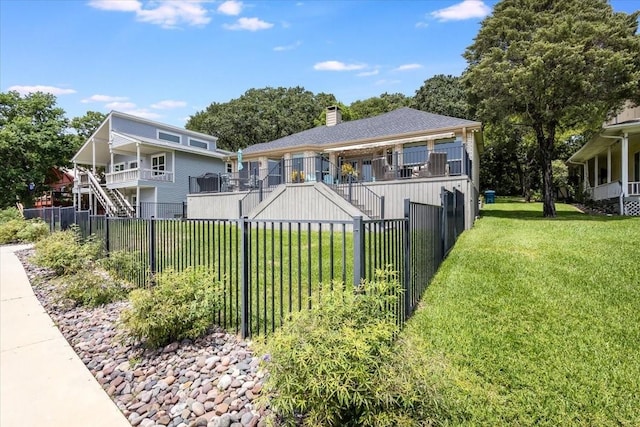 view of front of property featuring a front yard, stairway, a fenced backyard, and a chimney