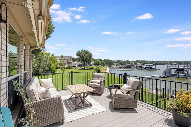 wooden terrace featuring an outdoor living space, a lawn, and a water view