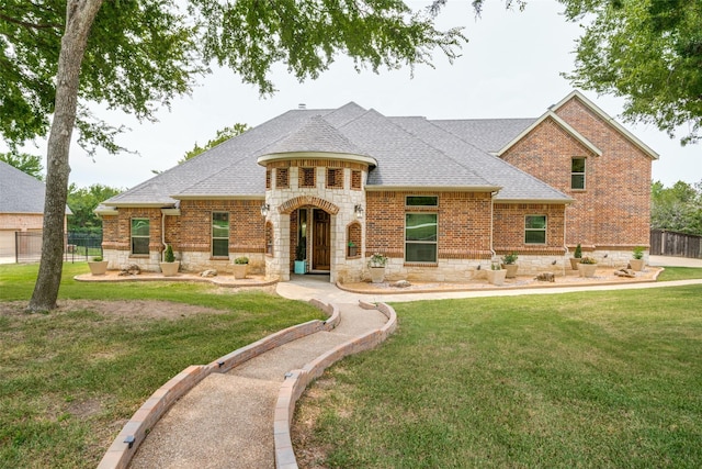 view of front of home featuring stone siding, brick siding, roof with shingles, and a front lawn