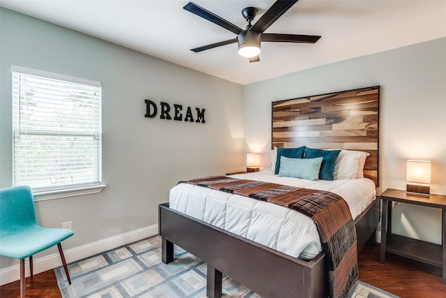 bedroom with a ceiling fan, baseboards, and wood finished floors