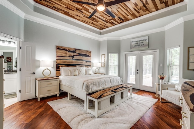 bedroom with dark wood-style floors, crown molding, a tray ceiling, and access to outside