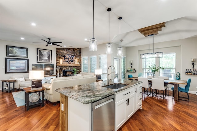 kitchen with dishwasher, a healthy amount of sunlight, light stone countertops, and a sink