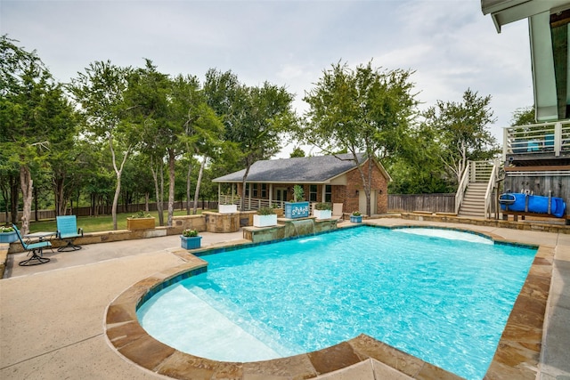 view of swimming pool featuring a patio, an outbuilding, a fenced backyard, and outdoor dry bar