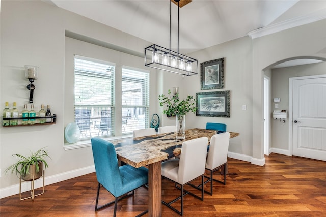 dining area with baseboards, arched walkways, and dark wood finished floors