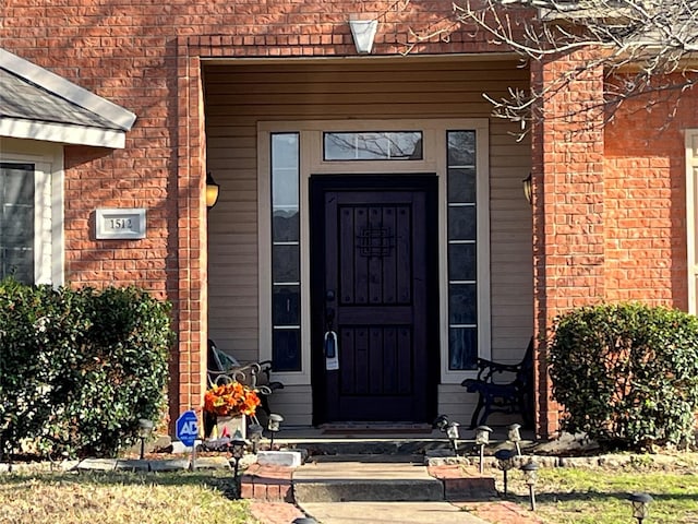 doorway to property featuring brick siding