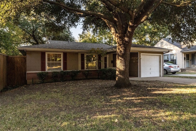 ranch-style home featuring concrete driveway, fence, a garage, and a shingled roof