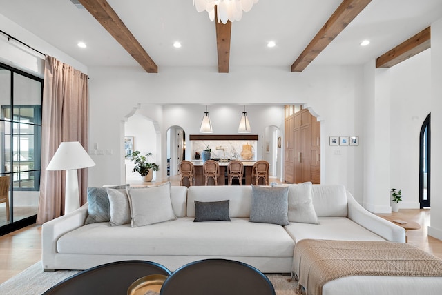 living room featuring arched walkways, recessed lighting, and wood finished floors