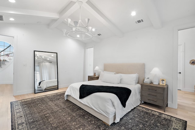 bedroom with visible vents, vaulted ceiling with beams, baseboards, light wood-type flooring, and an inviting chandelier